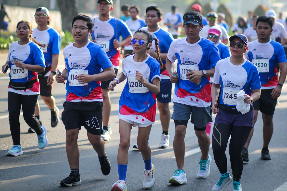 Group of runners in a road race, with a woman in blue sunglasses near the center